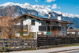 a house with a fence and mountains in the background at Berg Glück Axams in Innsbruck