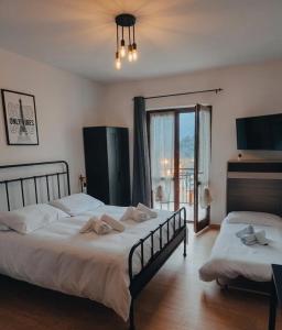 a bedroom with two beds and a large window at La Dimora di Alma in Clivio