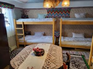 a room with two bunk beds and a table at Onodilak Guesthouse - Vendégház in Bîrzava