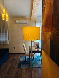 jadalnia ze stołem i żółtą lampą w obiekcie Eschilo Luxury House w mieście Carlentini