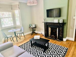 a living room with a fireplace and a tv at Briar & Bloom 1 in Hilton