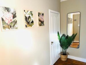 a hallway with three pictures on the wall and a potted plant at Briar & Bloom 1 in Hilton +8 photos