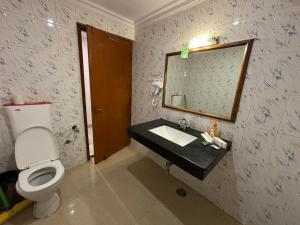 a bathroom with a toilet and a sink and a mirror at The Backpacker hostel by Surendra rajak in Khajurāho