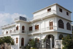 a white building with balconies on it at The Backpacker hostel by Surendra rajak in Khajurāho