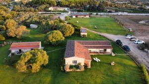 an aerial view of a house with cars parked on a field at B&B Majore in Olbia
