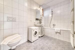 a bathroom with a toilet a sink and a washing machine at Gartenappartement Kirchdorf by A-Appartments in Brand