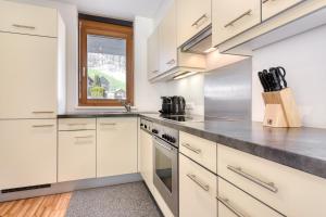 a kitchen with white cabinets and a window at Gartenappartement Kirchdorf by A-Appartments in Brand