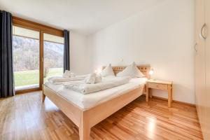 a bedroom with a bed with white pillows on it at Gartenappartement Kirchdorf by A-Appartments in Brand