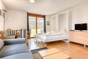a living room with a couch and a tv at Gartenappartement Kirchdorf by A-Appartments in Brand