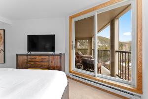 a bedroom with a bed and a large window at Pines #2124 in Keystone