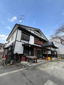 a black and white building with a bench in front of it at 民泊 シェアハウス北浦 in Senboku