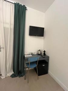 a room with a desk with a computer and a green curtain at El Nido Suite in Tornavento
