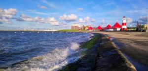 a beach with a lighthouse and a body of water at Hotel Münchner Löwenbräu in Cuxhaven