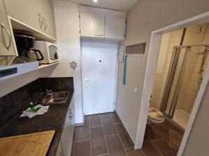 a small kitchen with a sink and a white door at Die lütte Kajüte Südstrand in Fehmarn