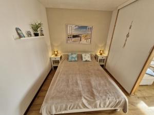 a small bedroom with a bed and two tables at Die lütte Kajüte Südstrand in Fehmarn +14 photos