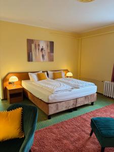 a bedroom with a large bed and a couch at Hotel Waldperle in Göhren