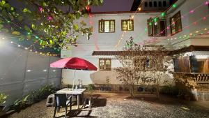 a table with a red umbrella in front of a building at Golden cypress resort with pool in Vythiri