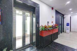 an elevator in a building with flowers in a planter at Status By Hotel The Emporio in Ghaziabad