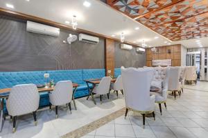 a dining room with tables and chairs and a wall at Status By Hotel The Emporio in Ghaziabad