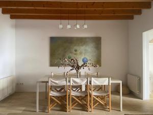 a dining room with a table and chairs and a painting at Puerto de Cala Ratjada in Cala Ratjada