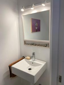 a bathroom with a white sink and a mirror at Puerto de Cala Ratjada in Cala Ratjada