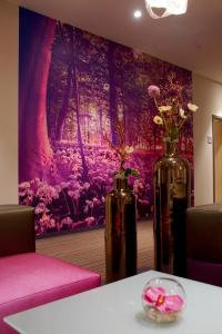 two vases sitting on a table with a painting at Centrale Hotel und Restaurant in Waldkraiburg +50 photos