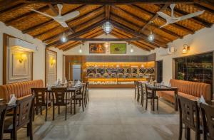 a dining room with tables and chairs and a bar at The Forest Chapter by Sayaji Madhai in Sohāgpur