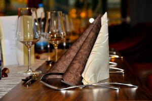 a table with napkins on a table with wine glasses at Centrale Hotel und Restaurant in Waldkraiburg