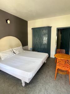 a bedroom with a large bed and a table at Green forest BnB and cafe in Manāli