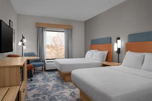 a hotel room with two beds and a television at Hampton Inn Crossville in Crossville +16 photos