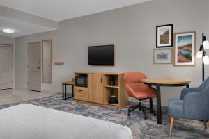 a room with a tv and a table and chairs at Hampton Inn Crossville in Crossville