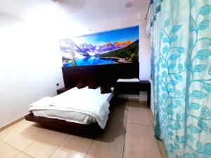 a bedroom with a bed and a large painting on the wall at Hotel Vivara in Lucknow