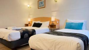 a hotel room with two beds and two lamps at Parkville Motel in Melbourne
