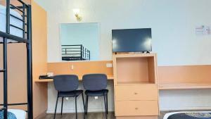 a room with two chairs and a desk with a television at Parkville Motel in Melbourne