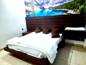 a bedroom with a bed with a large painting on the wall at Hotel Vivara in Lucknow +7 photos