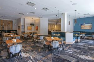 ein Restaurant mit Tischen und Stühlen in einem Raum in der Unterkunft DoubleTree by Hilton Hotel & Conference Centre Regina in Regina