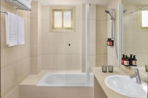 ein Badezimmer mit Badewanne und Waschbecken in der Unterkunft iStay by NH Zaragoza Sport Hotel in Saragossa