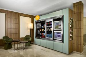 Eine Getränkebar mit zwei Stühlen und einem Kühlschrank in der Unterkunft iStay by NH Zaragoza Sport Hotel in Saragossa