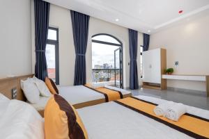 a bedroom with two beds and a large window at Villa 5 Lạc Long Quân - Bãi Sau in Vung Tau +40 photos