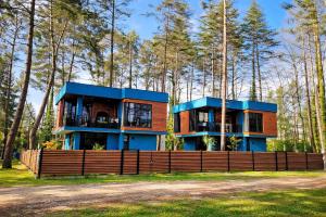 a house in the woods with a wooden fence at Black Sea Gemini in Ureki