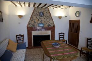 a living room with a table and a fireplace at El Molino de Batán in Galera