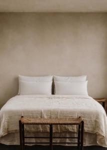 a bed with white sheets and pillows on it at Cortijo Sol y Olivo spacious exclusive private pool retreat in Algarinejo