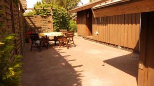 a patio with a table and chairs next to a building at Stolley - Ferienhaus mit Garten, Kamin und Sauna in Silberstedt