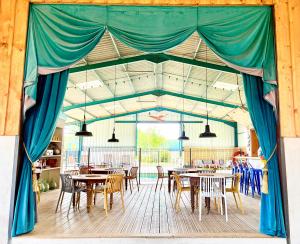 a tent with tables and chairs in a restaurant at La roulotte MAGIC ! des Grillots in Beaulon