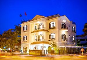 a large white building with windows and balconies at night at Garco Dragon Hotel in Hanoi