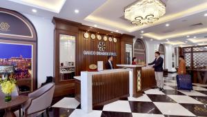 a lobby of a store with two people standing at a counter at Garco Dragon Hotel in Hanoi