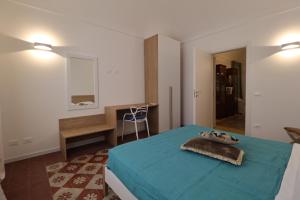 a bedroom with a blue bed and a desk at Mastru Cicciu in Custonaci