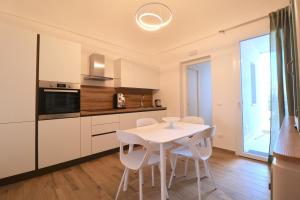 a kitchen with a white table and white chairs at Mastru Cicciu in Custonaci +20 photos