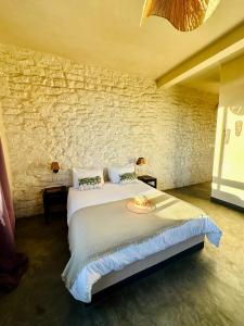 a bedroom with a large bed in a stone wall at Villa Azir in Ghazoua +32 photos