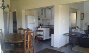 una cucina e una sala da pranzo con tavolo, cucina e tavolo con sedie di 37 Valley View Cottage a Underberg Altre 5 foto